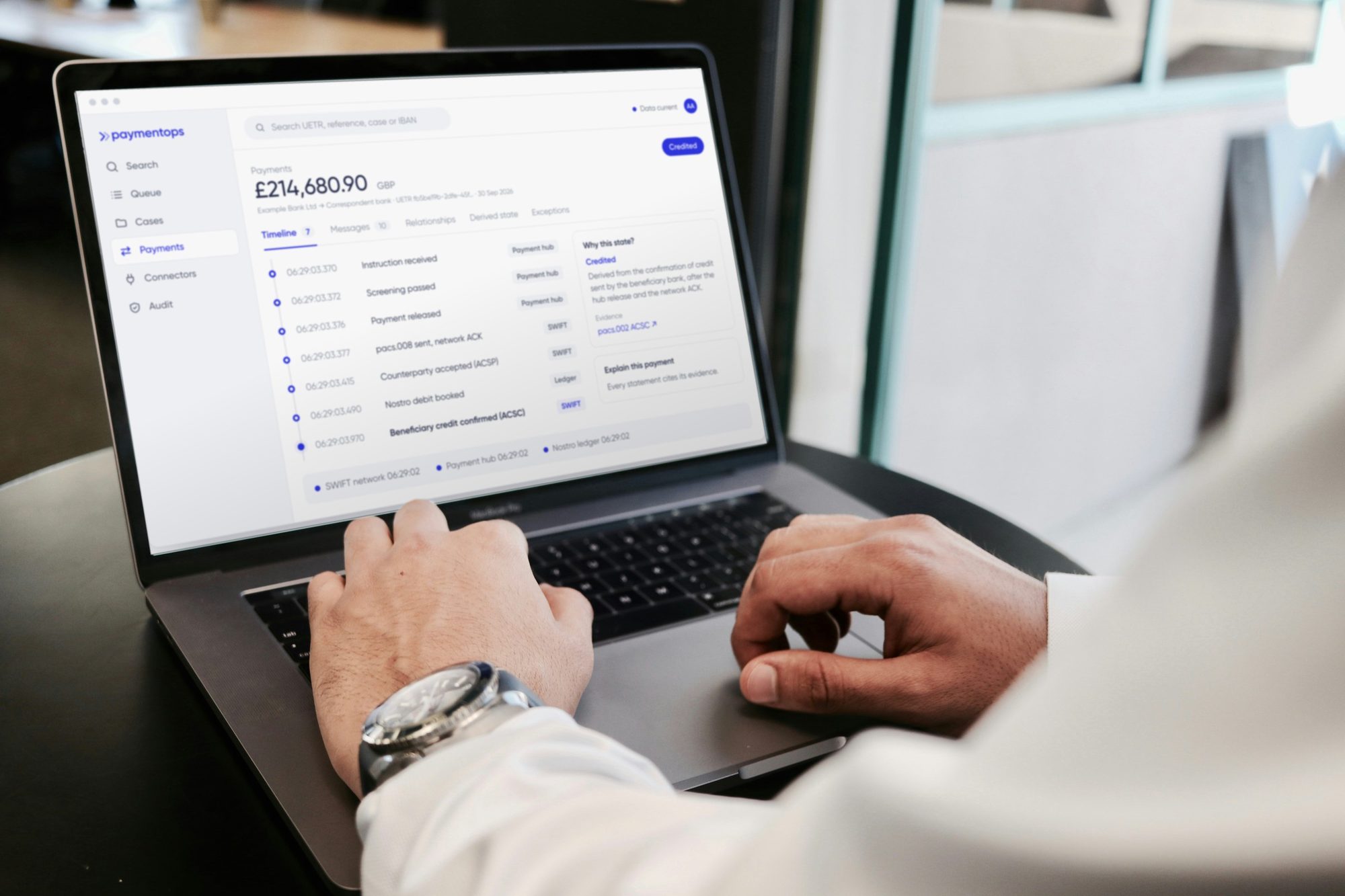 An operations analyst using PaymentOps on a laptop to trace an international payment across the payment hub, SWIFT and ledger.